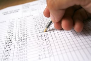 Hand ticking off boxes on a paper checklist