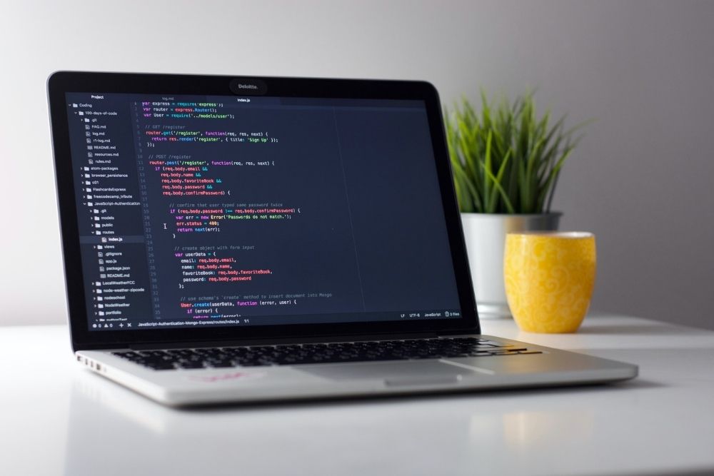 Laptop on a desk with code